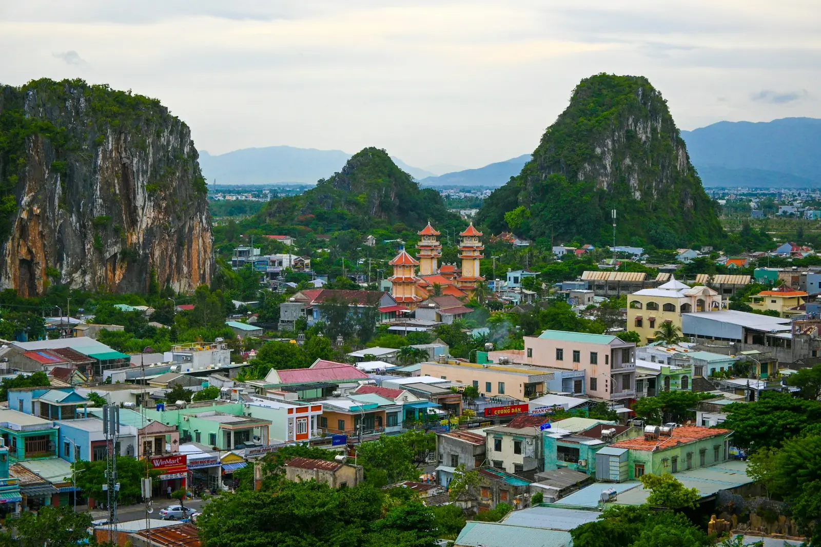 Kalksteinsfjellene i Ngu Hanh Son reiser seg over hustakene og et tempel i Da Nang