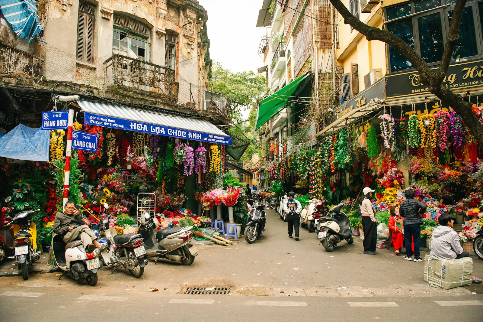 Gate i Gamlebyen i Hanoi med fargerike butikker og parkerte motorsykler