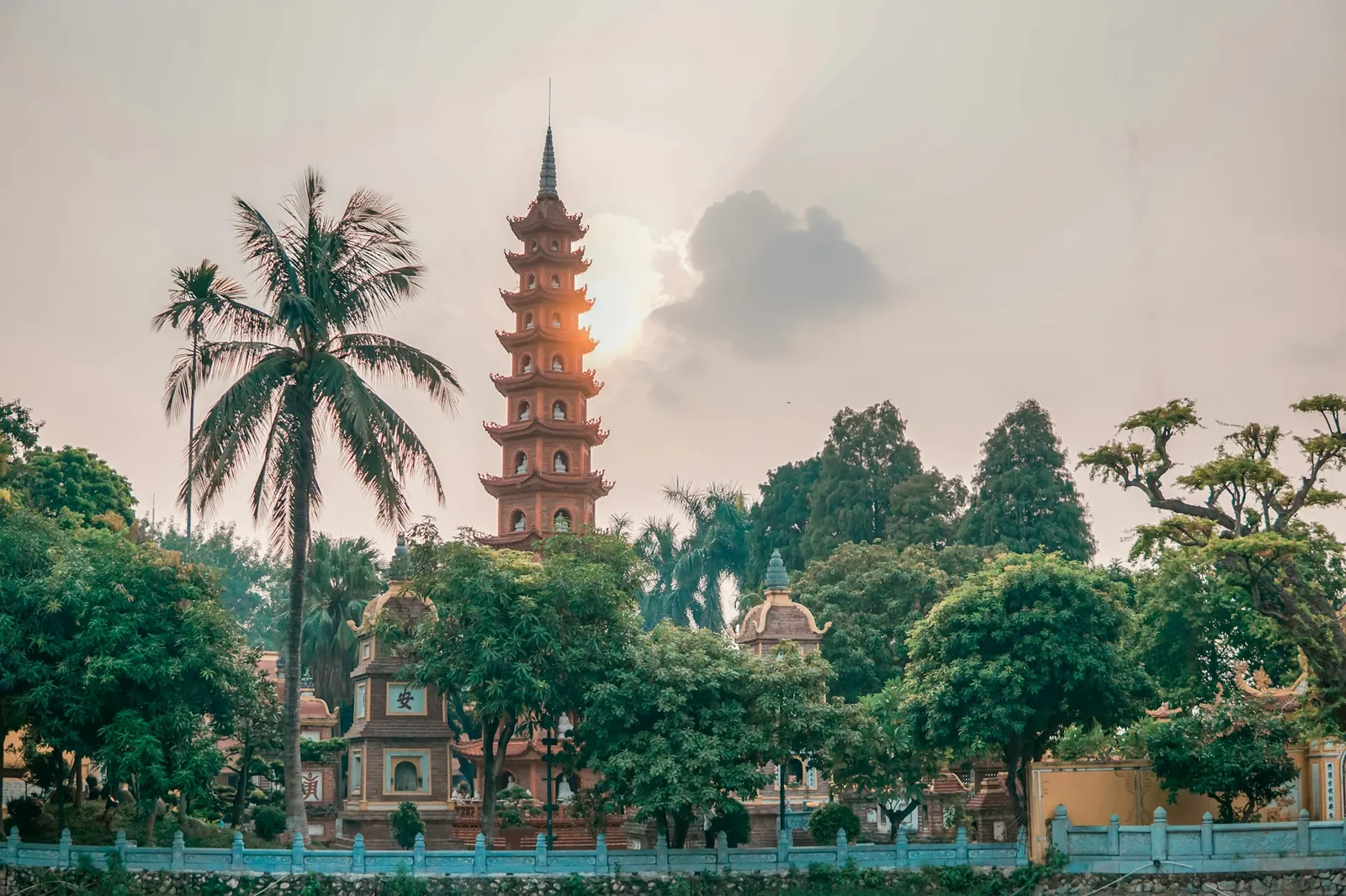 Tran Quoc-pagoden med kokospalme ved Vestsjøen i Hanoi i kveldslys