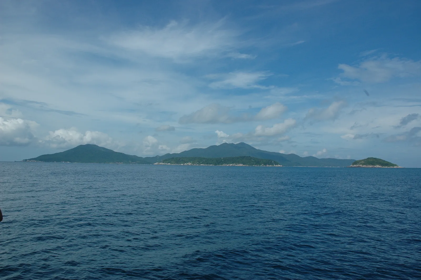 Cu Lao Cham-øyene med grønne åser sett fra havet under blå himmel