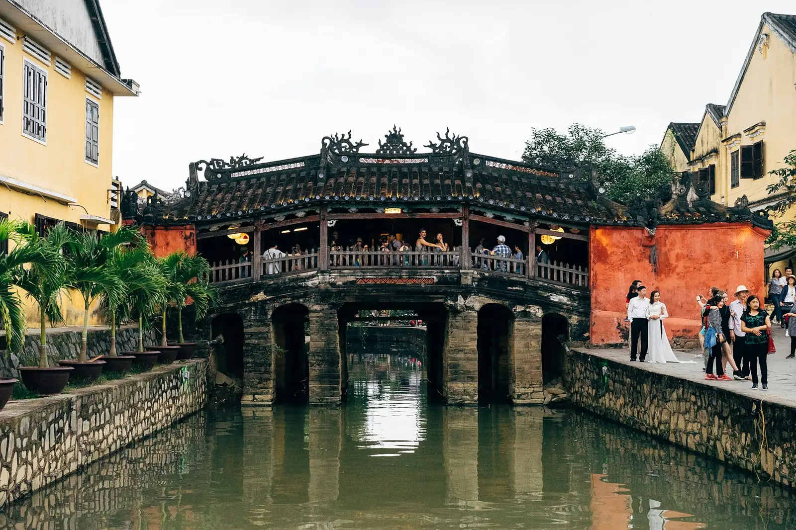 Den japanske broen i Hoi An over en kanal med turister