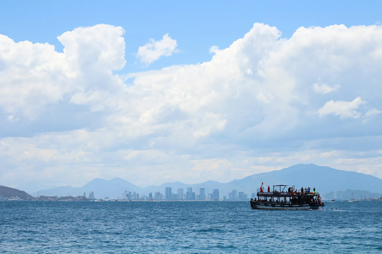 Turbåt på havet utenfor Nha Trang med byens skyline i horisonten