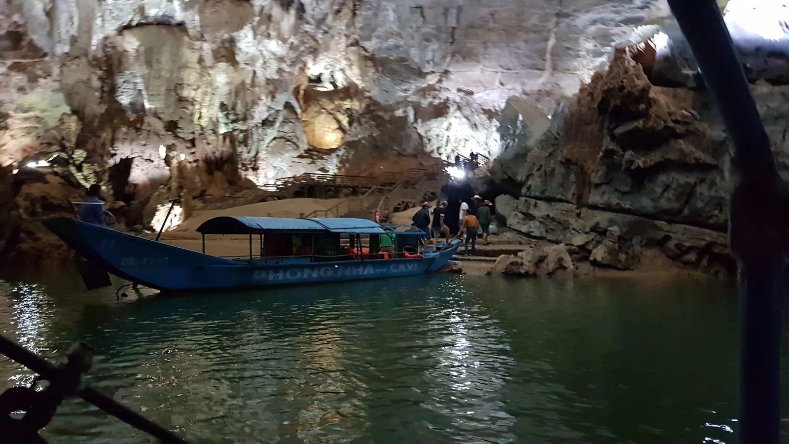 Turistbåt på den underjordiske elva inne i Phong Nha-grotta