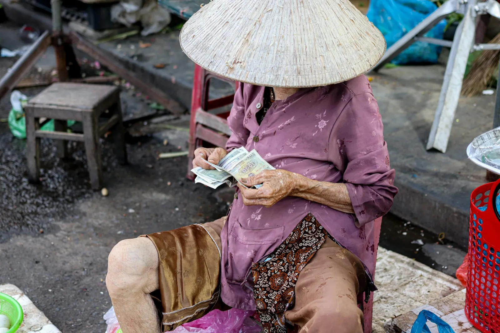 Eldre markedshandler teller vietnamesiske dongsedler