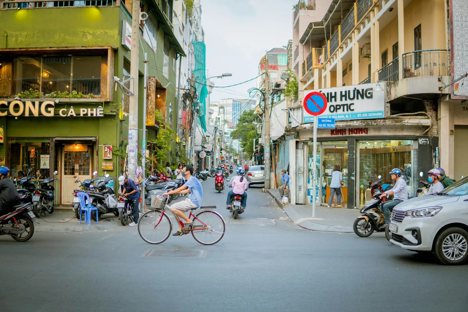 Gatehjørne med kafé og syklist i Ho Chi Minh-byen