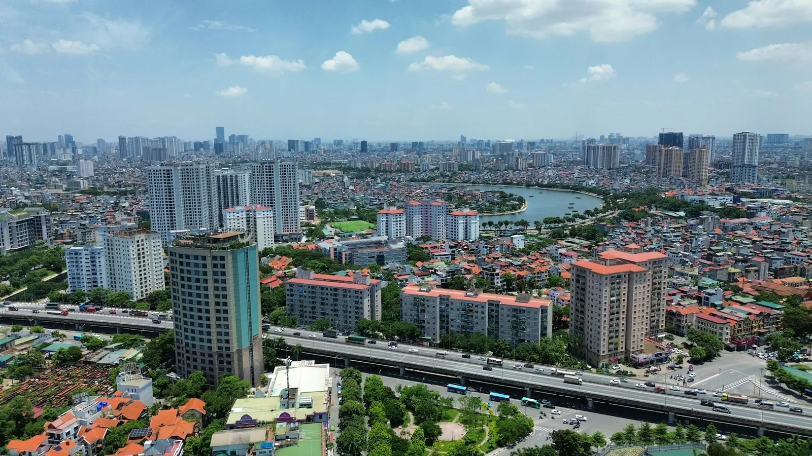 Leilighetsblokker, innsjø og motorvei i Hanoi sett fra luften