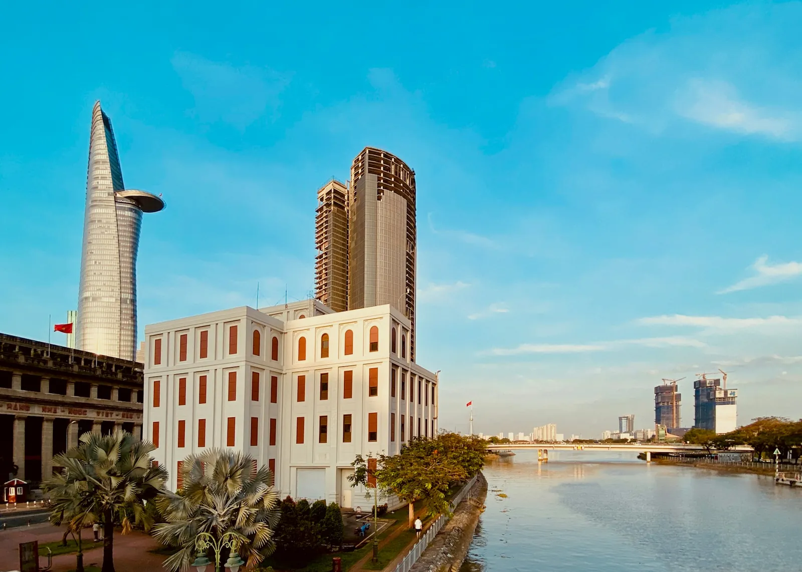 Saigon-elva i Ho Chi Minh-byen med Bitexco-tårnet og eldre bygninger i kveldssol