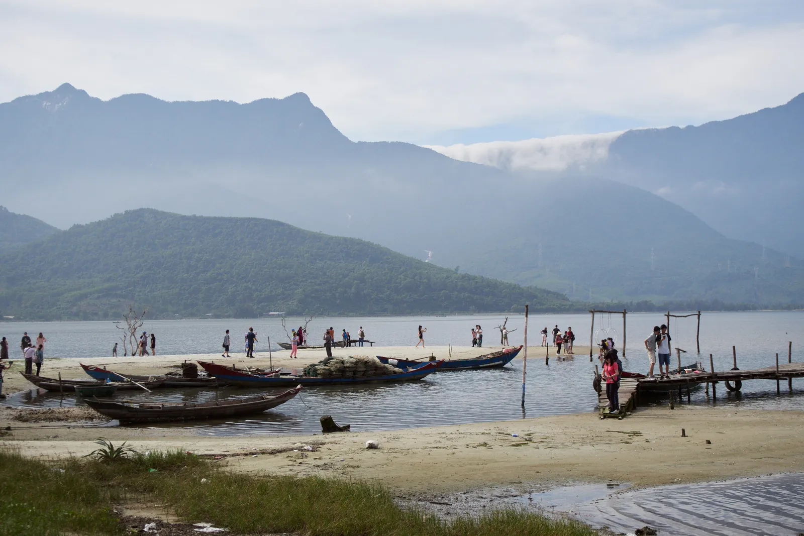 Lagunen ved Lang Co med fiskebåter, sandbanke og tåkehengte fjell bak