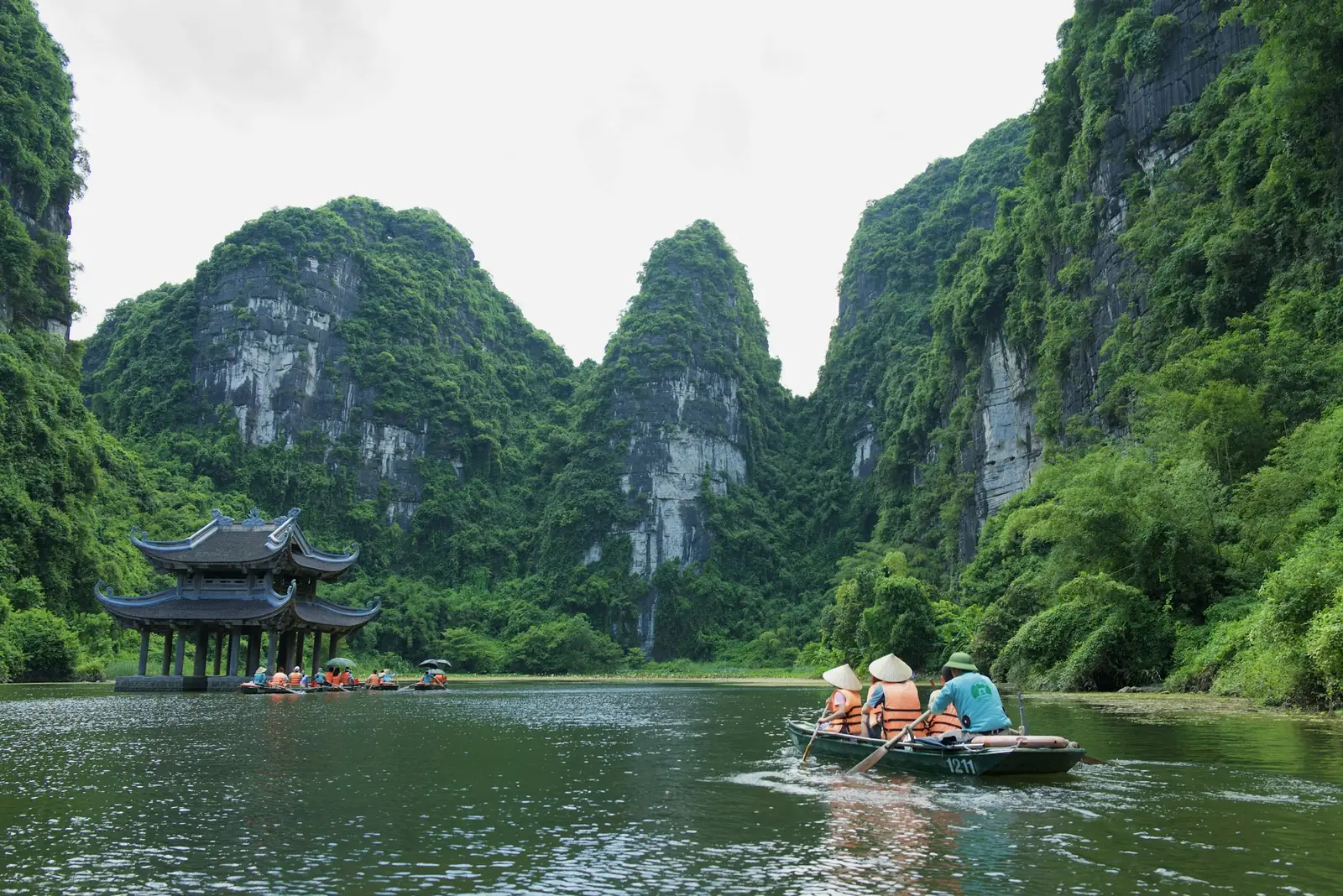 Paviljong ved vannet og kalksteinsfjell i Trang An nær Ninh Binh