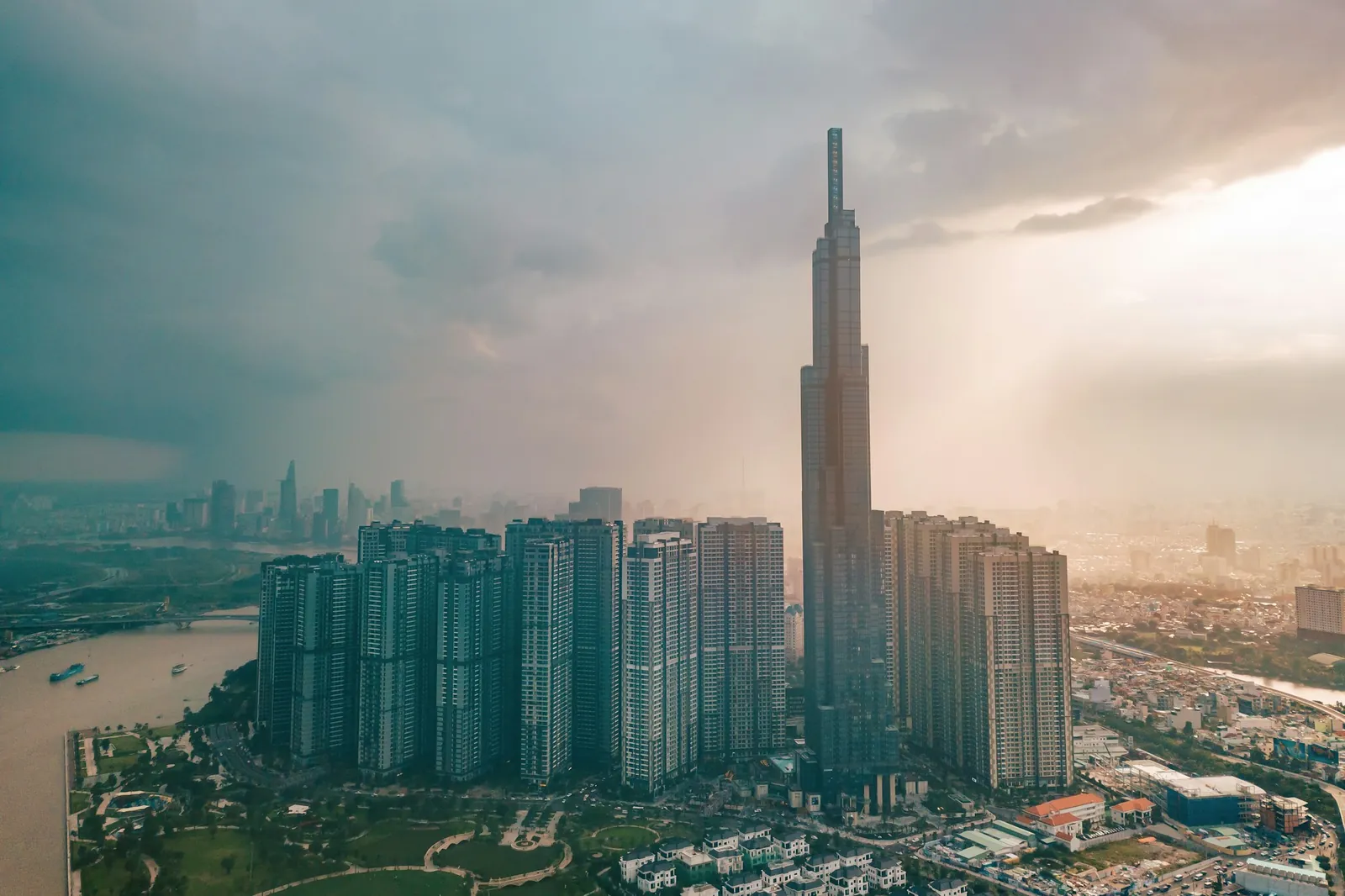 Flyfoto av Landmark 81 og høyhus ved Saigon-elva under truende skyer i Ho Chi Minh-byen