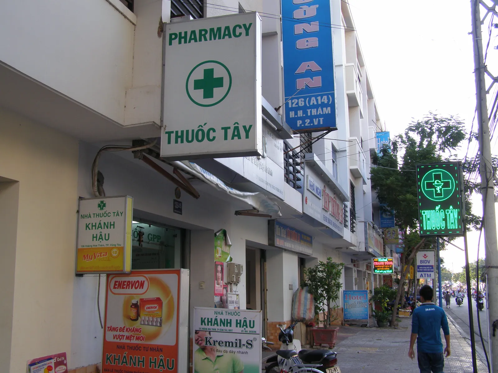 Apotekskilt med grønt kors og teksten Thuốc Tây på en gate i Vũng Tàu