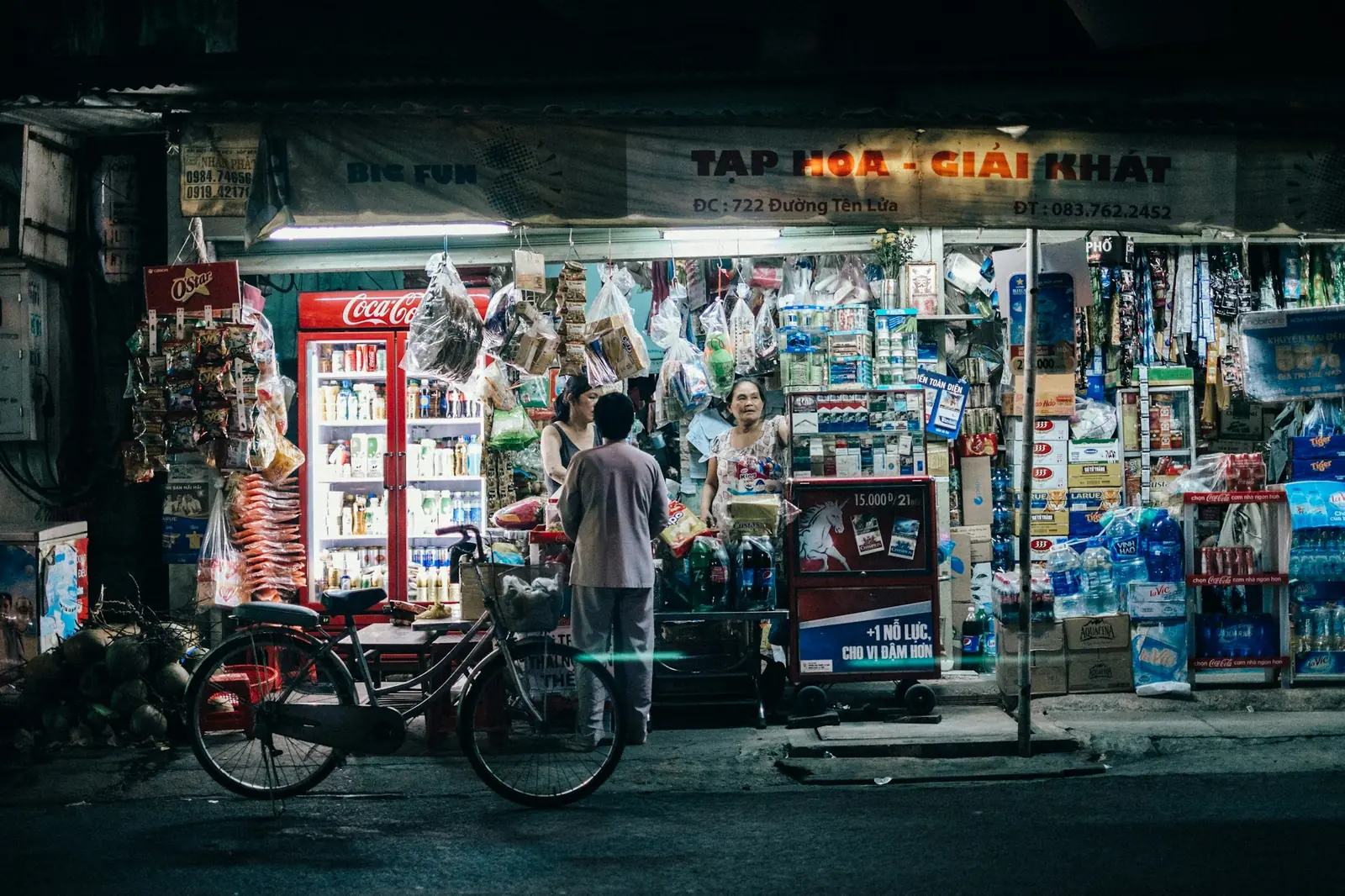 Kveldsåpen kiosk i Ho Chi Minh-byen med kjøleskap og pakker med flaskevann