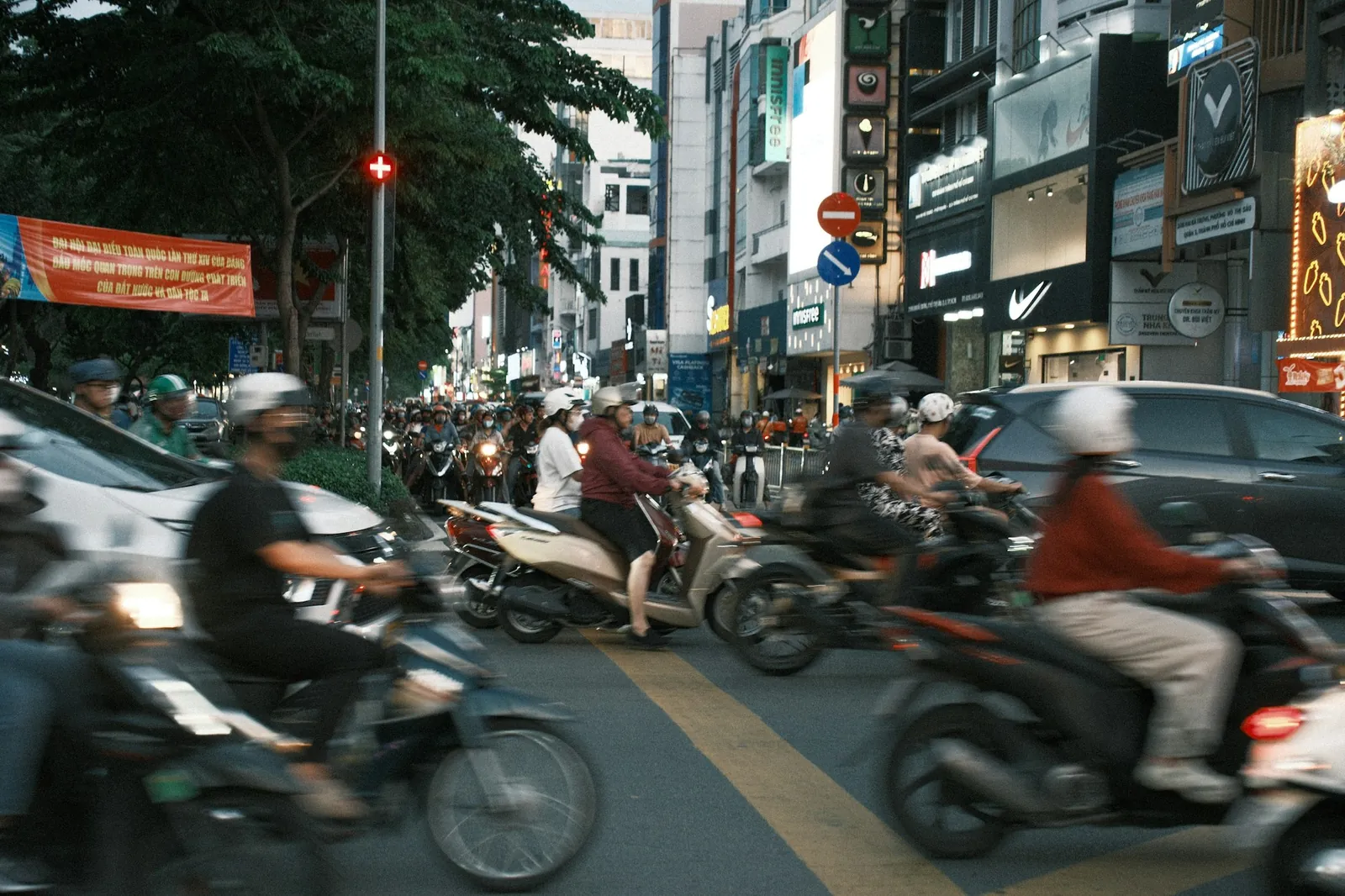 Tett motorsykkeltrafikk i en vietnamesisk storby, flere med munnbind