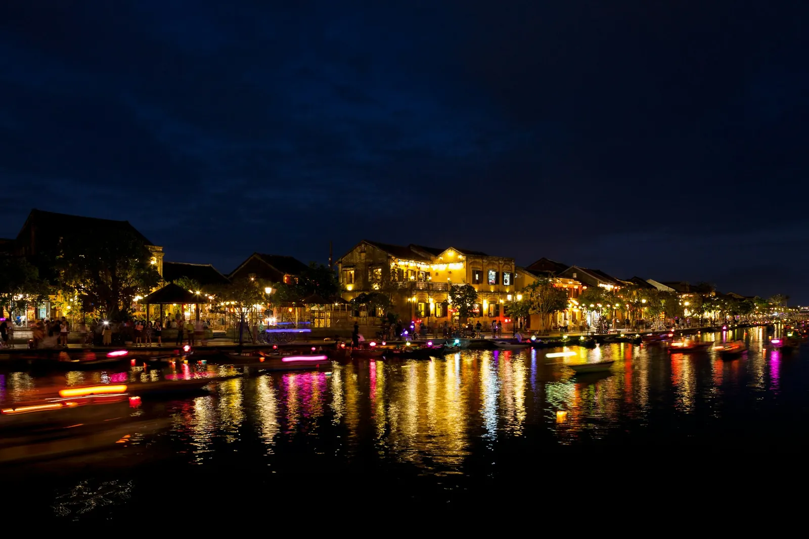 Gamlebyen i Hoi An om kvelden med opplyste hus som speiler seg i Thu Bon-elva