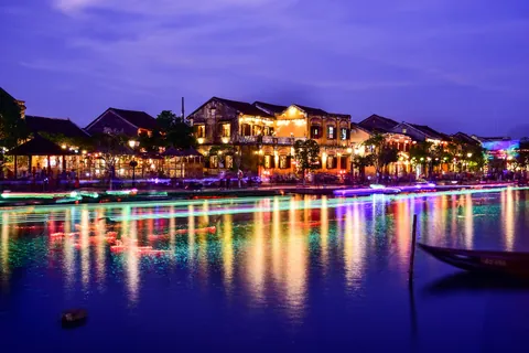 Gamlebyen i Hoi An ved blå time med lysende reflekser i elva