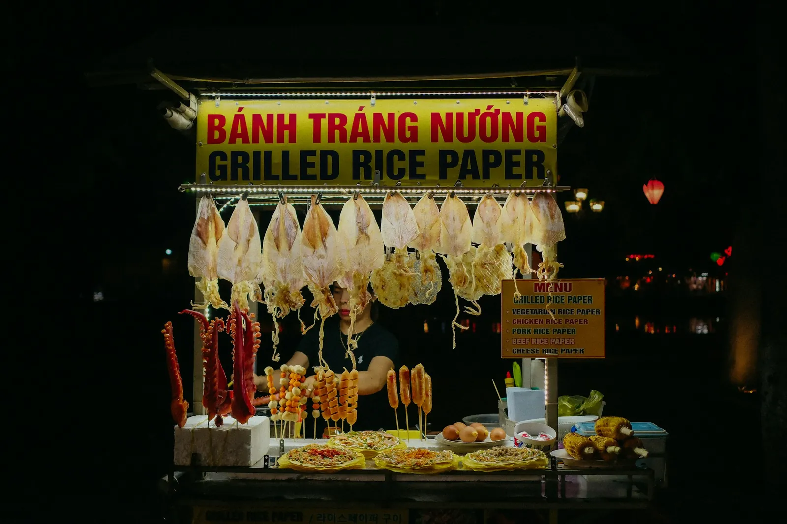 Nattstand med skilt på vietnamesisk og engelsk: Bánh tráng nướng