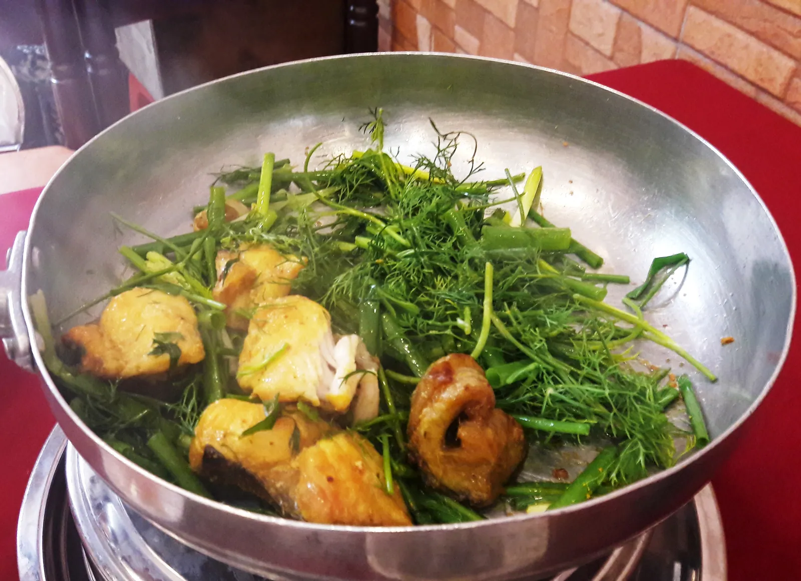 Cha ca La Vong: stekt fisk med dill og vårløk i panne på bordet i Hanoi
