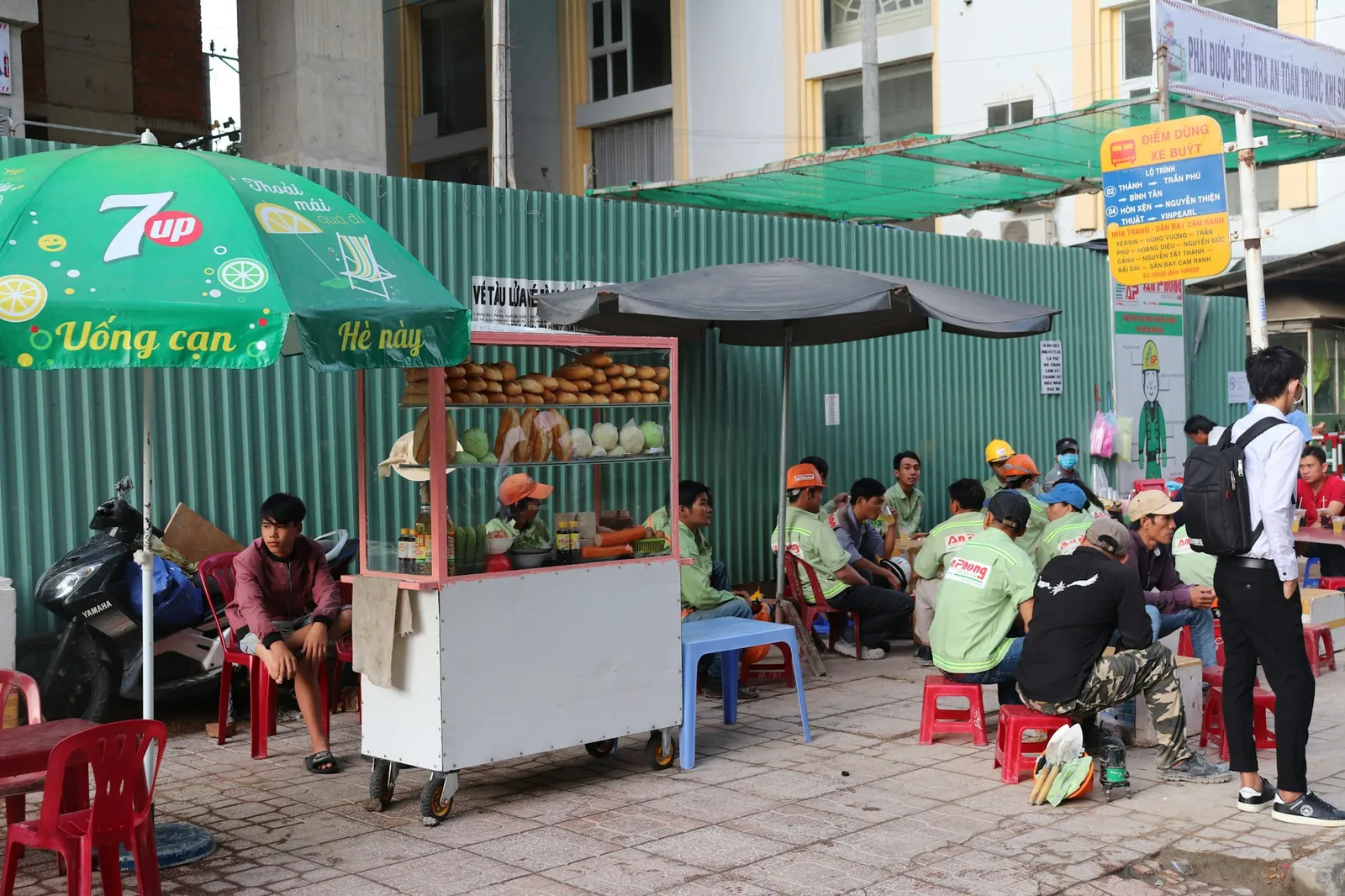 Banh mi-vogn og arbeidere på plastkrakker langs en gate i Vietnam