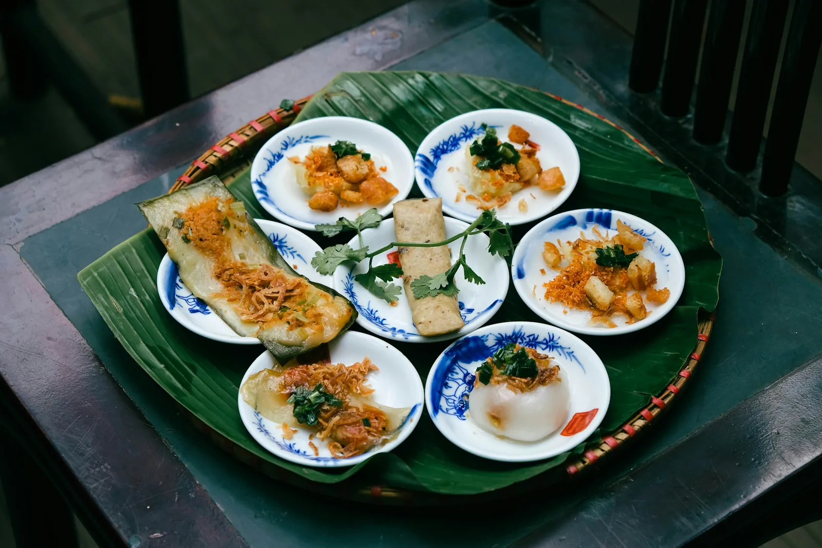Små tallerkener med risretter på bananblad, slik de serveres i sentral-Vietnam