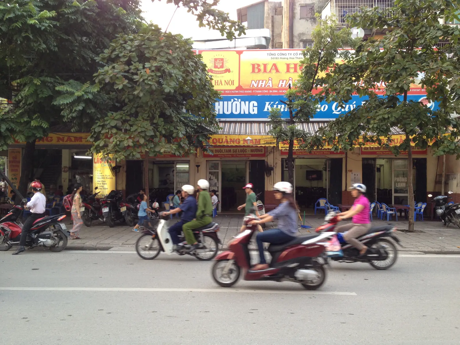 Bia hơi-utsalg fra Bia Hà Nội langs en gate i Hanoi med scootere i forgrunnen