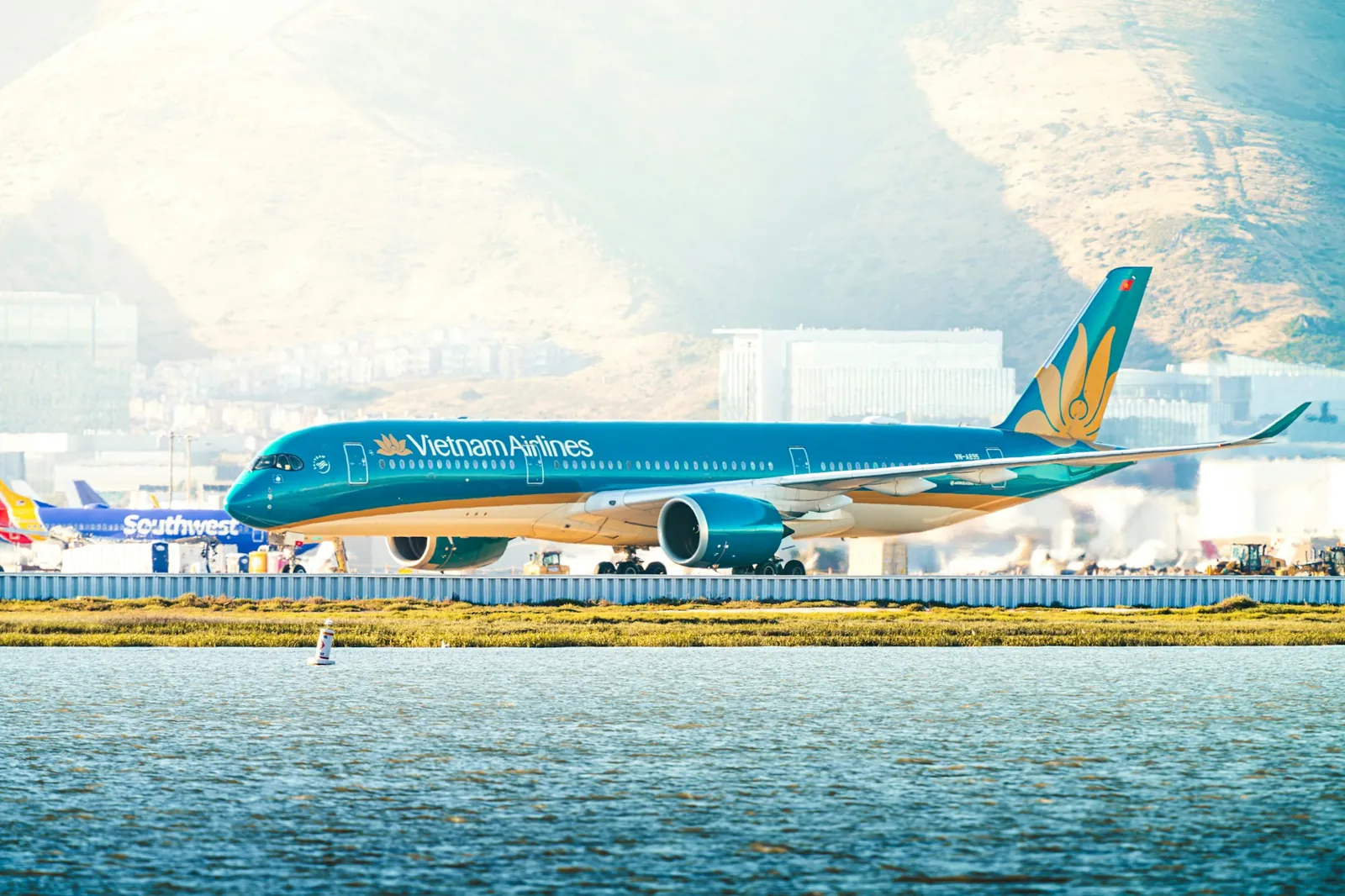 Fly fra Vietnam Airlines på rullebanen med hav i forgrunnen