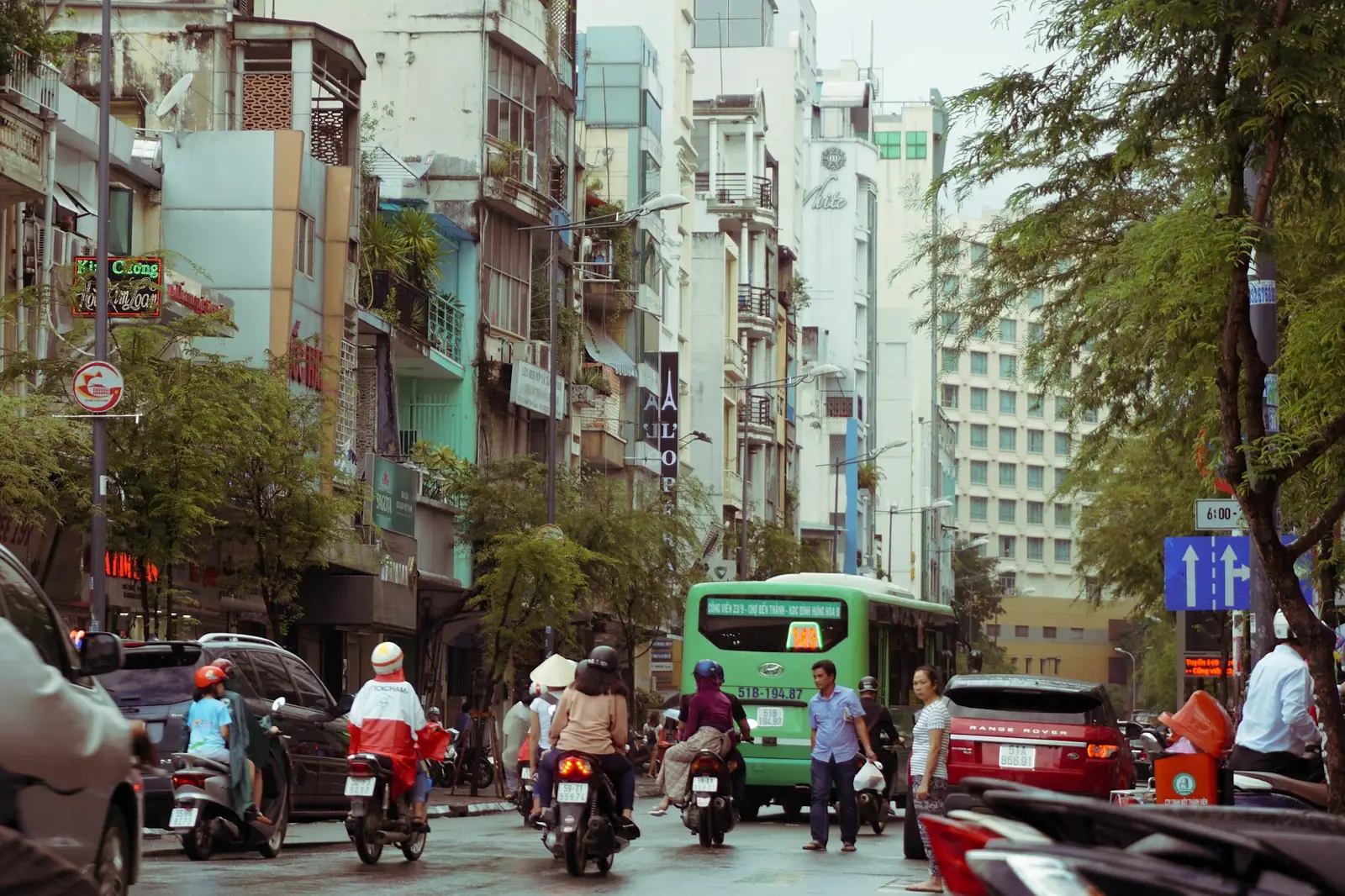 Trafikk med motorsykler og buss i en gate i Ho Chi Minh-byen