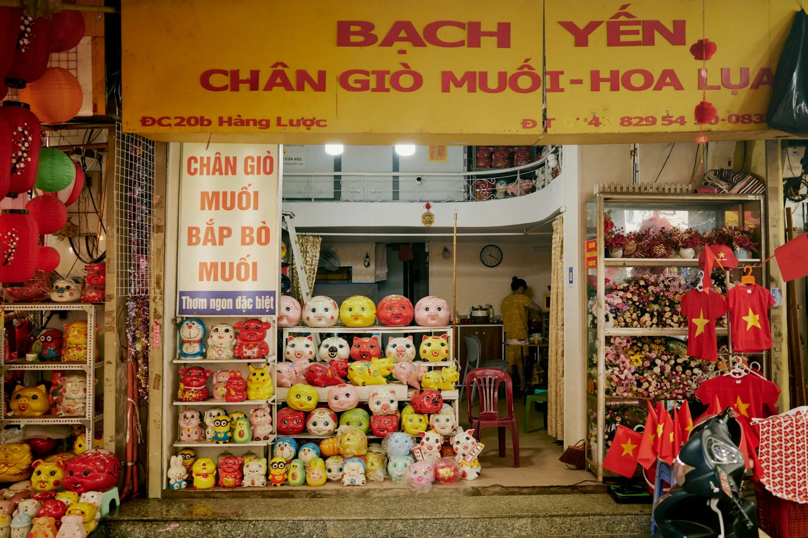 Butikk i Hang Luoc-gata i Hanoi med vietnamesiske skilt, sparegriser og flagg